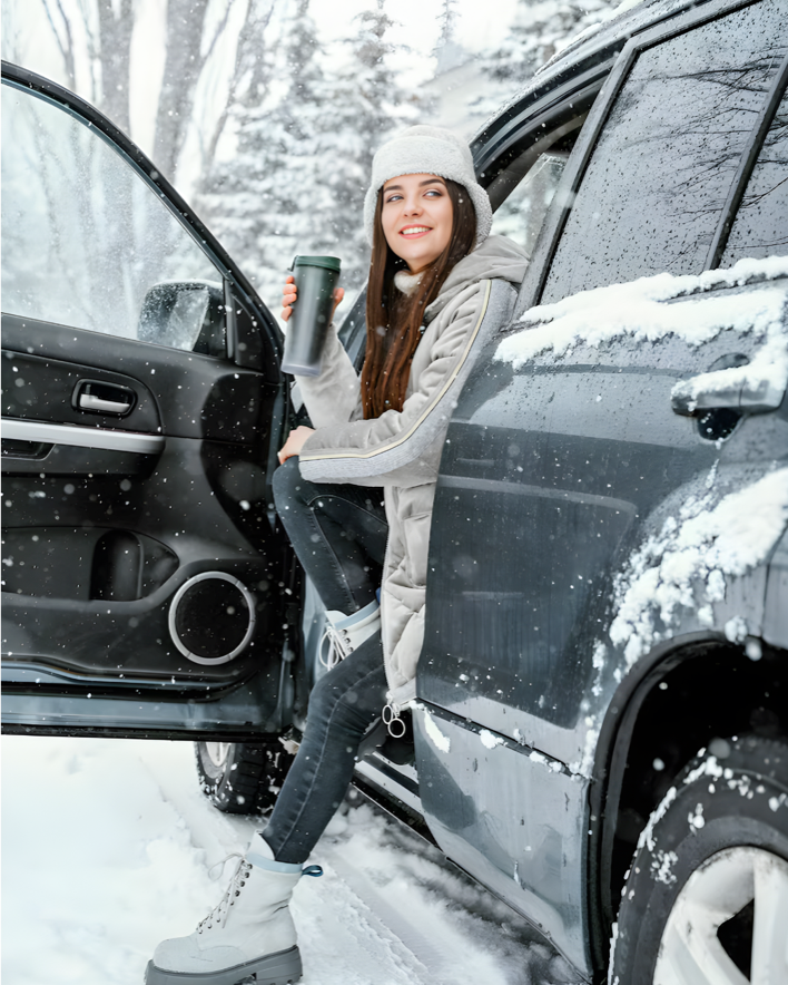 chica en un coche del servicio de alquiler de vehiculos de alvemaco rent en asturias en una carretera con nieve
