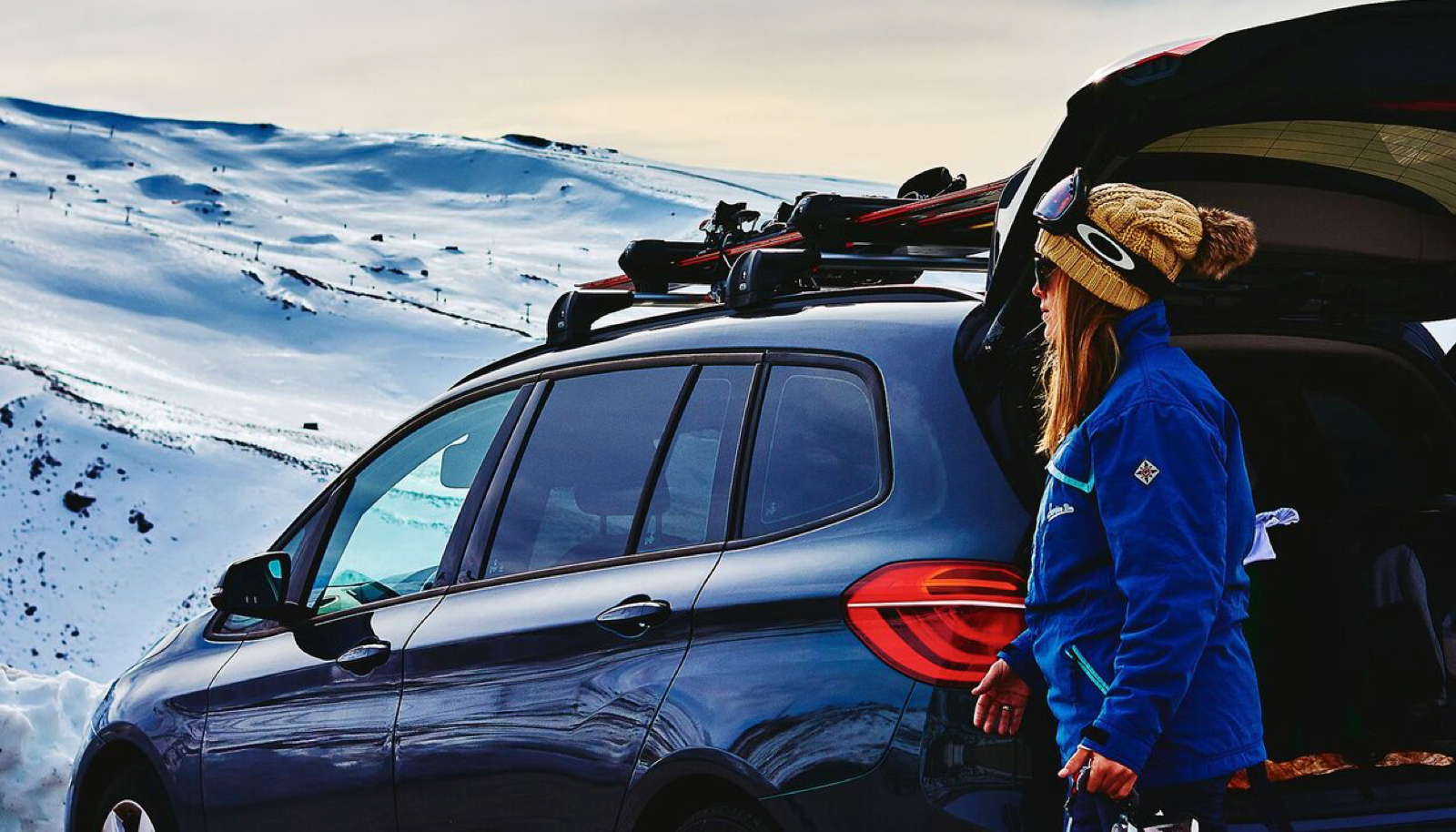 imagen del banner que muestra a una mujer con equipo de esqui y su coche de alquiler de alvemaco rent en asturias